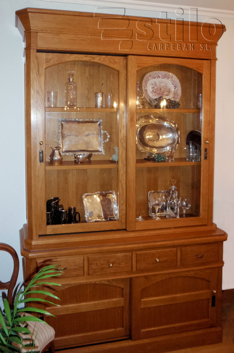 Vista de mueble de comedor realizado en madera de roble. Estilo castellano. En la parte superior dispone de puertas correderas que se cierra con llave y en la parte inferior tiene varios cajones y puertas correderas.  Carpintera Ebanistera Carpeban Stil